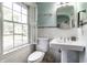 Bright bathroom featuring a pedestal sink, white tiles, and natural light at 5261 N Pennsylvania St, Indianapolis, IN 46220