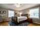 Cozy bedroom with wood floors, grey walls, a ceiling fan, and windows at 5261 N Pennsylvania St, Indianapolis, IN 46220