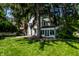Exterior of a home surrounded by a lush, green lawn and mature trees, partially obscuring the facade at 5261 N Pennsylvania St, Indianapolis, IN 46220