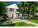 Exterior of the home with stone patio, lush landscaping, and a glimpse of the charming architecture at 5261 N Pennsylvania St, Indianapolis, IN 46220