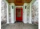 Inviting front entrance features brickwork, columns, black lighting fixtures and a vibrant red door at 5261 N Pennsylvania St, Indianapolis, IN 46220