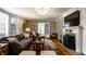 Bright living room featuring hardwood floors, fireplace, chandelier, and an abundance of natural light at 5261 N Pennsylvania St, Indianapolis, IN 46220