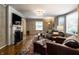 Cozy living room with a fireplace, hardwood floors, and stylish furnishings under a chandelier at 5261 N Pennsylvania St, Indianapolis, IN 46220