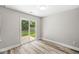 Bedroom featuring modern wood-look flooring and sliding glass doors leading to the fenced in backyard at 5289 Pine Hill Dr, Noblesville, IN 46062