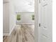 Bedroom featuring modern wood-look flooring, two windows overlooking yard, and fresh neutral paint at 5289 Pine Hill Dr, Noblesville, IN 46062