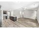 Open-concept living area featuring vaulted ceiling, wood-look floors, bar to kitchen, and modern design at 5289 Pine Hill Dr, Noblesville, IN 46062