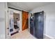 A charming kitchen with a sliding barn door and modern black refrigerator at 608 W 600 N, Fortville, IN 46040