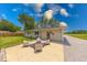 This backyard features a concrete patio with seating and beautiful green grass surrounded by mature trees at 608 W 600 N, Fortville, IN 46040