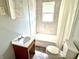 Tiled bathroom featuring a window, bathtub, toilet, and sink with vanity at 613 N Tacoma Ave, Indianapolis, IN 46201