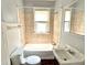 Bathroom featuring a bathtub, tiled wall, sink, toilet and window at 613 N Tacoma Ave, Indianapolis, IN 46201