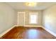 Bedroom features wood floor, a door, and a window with blinds at 613 N Tacoma Ave, Indianapolis, IN 46201