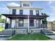 Two-story home featuring a covered front porch and vinyl siding for a classic look at 613 N Tacoma Ave, Indianapolis, IN 46201