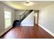 Living room showing hardwood floors, neutral paint, and view of stairway at 613 N Tacoma Ave, Indianapolis, IN 46201