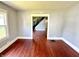 Living room featuring hardwood floor, neutral paint, and view of stairway at 613 N Tacoma Ave, Indianapolis, IN 46201