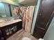 Well-appointed bathroom with a marble vanity, decorative shower curtain, and wood look floor at 627 Plum St, Noblesville, IN 46060