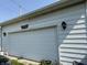 Spacious two-car garage with white siding and decorative eagle emblem above the door at 627 Plum St, Noblesville, IN 46060