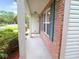 View of the covered front porch of a brick home with green shutters and vinyl siding at 6412 Cradle River Dr, Indianapolis, IN 46221