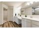 Modern bathroom with double vanity, granite countertops, and a large mirror and wood-look floors at 6537 Seabiscuit Rd, Whitestown, IN 46075