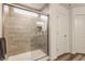 Stylish bathroom showcasing a glass-enclosed shower with light wood-like tiles and updated fixtures at 6537 Seabiscuit Rd, Whitestown, IN 46075