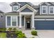 Covered entrance with stone accents, blue siding, and well maintained landscape at 6537 Seabiscuit Rd, Whitestown, IN 46075
