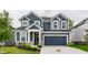 Two-story home featuring blue siding, white trim, a two-car garage and landscaping at 6537 Seabiscuit Rd, Whitestown, IN 46075