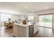 Bright open concept kitchen featuring a kitchen island, stainless steel dishwasher, and an open floor plan at 6537 Seabiscuit Rd, Whitestown, IN 46075