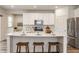 Bright kitchen features a large island with seating, stainless steel appliances, and white cabinets at 6537 Seabiscuit Rd, Whitestown, IN 46075