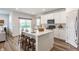 Bright kitchen with a large island, bar stool seating, stainless appliances, and sliding glass door at 6537 Seabiscuit Rd, Whitestown, IN 46075