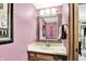 Powder room with pink walls, decorative mirror, and vanity at 664 N Scott Dr, Greenwood, IN 46142