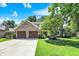Charming two-story brick home with a well-manicured lawn, mature trees, and an attached two-car garage at 664 N Scott Dr, Greenwood, IN 46142