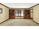 Spacious living room with large windows, custom wood bookshelves, and plush carpeting at 664 N Scott Dr, Greenwood, IN 46142