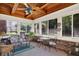 Comfortable sunroom featuring wicker furniture, brick accents and windows with backyard views at 664 N Scott Dr, Greenwood, IN 46142