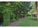 Lush backyard featuring manicured landscaping and mature trees, creating a private and serene outdoor oasis at 7029 Kingswood Cir, Indianapolis, IN 46256