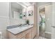 Bathroom showcasing pink vanity with granite countertop and a view to the hall at 7029 Kingswood Cir, Indianapolis, IN 46256