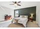 Comfortable bedroom with a green accent wall, ceiling fan, and natural light from a window at 7029 Kingswood Cir, Indianapolis, IN 46256