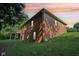 Exterior view of the brick home at sunset, with its deck and large lawn, showcasing its curb appeal at 7029 Kingswood Cir, Indianapolis, IN 46256