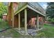 Rear exterior view of the home with covered deck, showcasing the building's design and landscaping at 7029 Kingswood Cir, Indianapolis, IN 46256