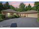 Brick house featuring an attached garage, asphalt driveway, and tasteful landscaping under a vibrant sky at 7029 Kingswood Cir, Indianapolis, IN 46256