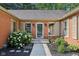 Charming front entrance with brick facade, decorative shutters, and beautifully landscaped walkway at 7029 Kingswood Cir, Indianapolis, IN 46256