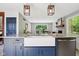 Modern kitchen featuring a blue island with a farmhouse sink and granite countertops at 7029 Kingswood Cir, Indianapolis, IN 46256