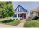 Charming blue home with a red door, green lawn, and inviting curb appeal at 712 Orange St, Indianapolis, IN 46203