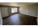 Inviting living room with sleek, dark flooring, freshly painted walls, a bright window, and a classic white door at 7641 E 35Th St, Indianapolis, IN 46226
