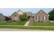 Charming brick home featuring a well-manicured lawn, mature landscaping, and inviting front entrance at 8028 Meadow Bend Ln, Indianapolis, IN 46259