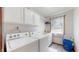 Well-lit laundry room with white cabinets and modern washer and dryer at 8028 Meadow Bend Ln, Indianapolis, IN 46259