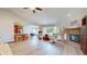 Open living room featuring a brick fireplace, vaulted ceiling, and seamless flow to kitchen at 8028 Meadow Bend Ln, Indianapolis, IN 46259