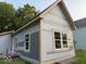 This exterior shot shows a light colored house featuring new windows and light trim at 827 W 9Th St, Anderson, IN 46016