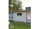 This exterior shot shows a light colored house featuring a new door and light trim at 827 W 9Th St, Anderson, IN 46016