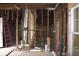Framing of a room displaying stud work, HVAC ducting, and utility lines showcasing a construction phase at 827 W 9Th St, Anderson, IN 46016