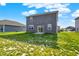 The spacious backyard has a gray house with a sliding glass door and a mix of green grass and exposed dirt at 851 Sonoma Ln, Greenfield, IN 46140