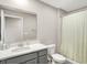 A bathroom with a gray vanity, a toilet, and a shower with a neutral curtain at 851 Sonoma Ln, Greenfield, IN 46140